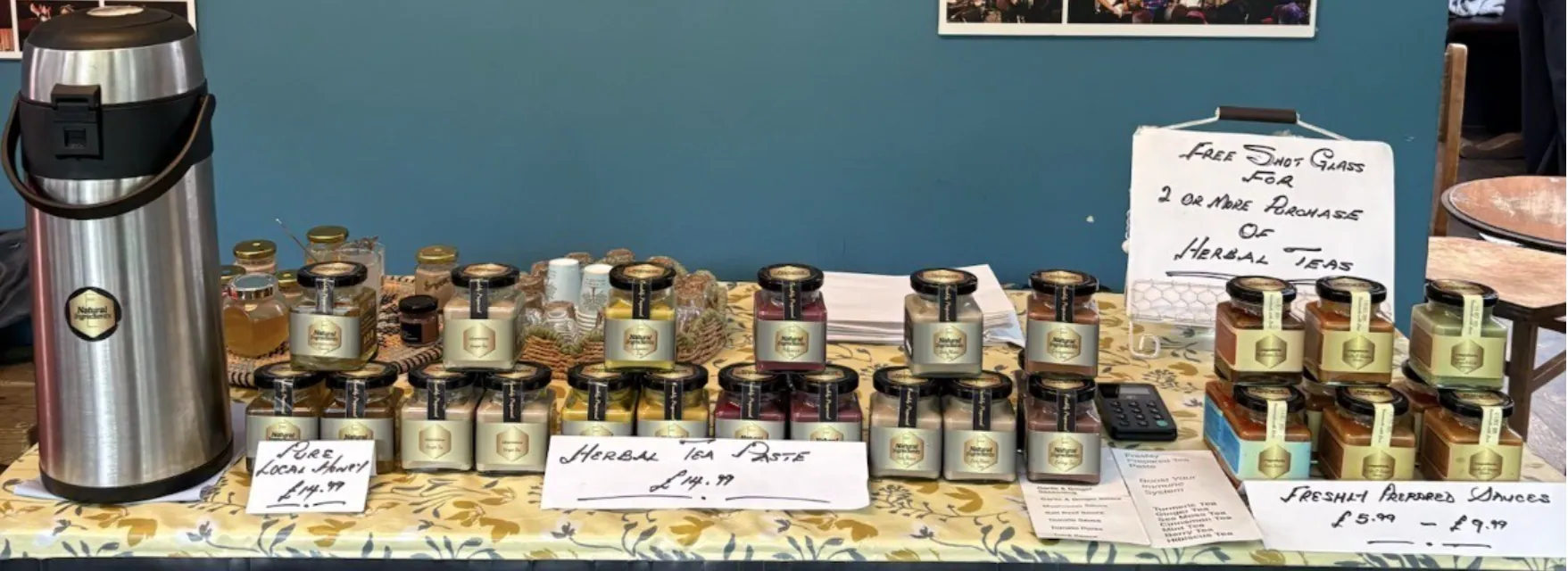 The I Natural Ingredients market stall with local honey displayed beside the jar range.
