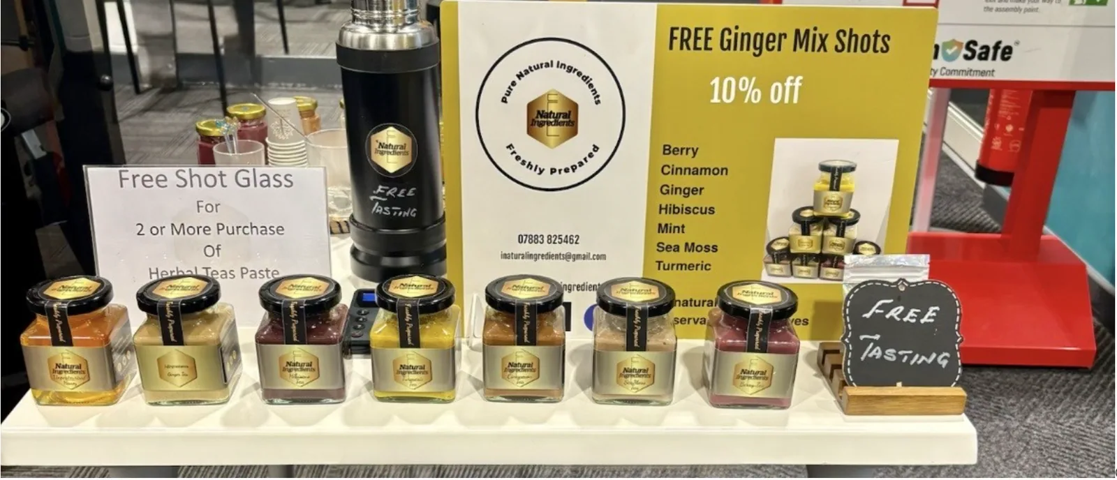 Herbal tea paste jars lined up in front of the I Natural Ingredients flavour board.